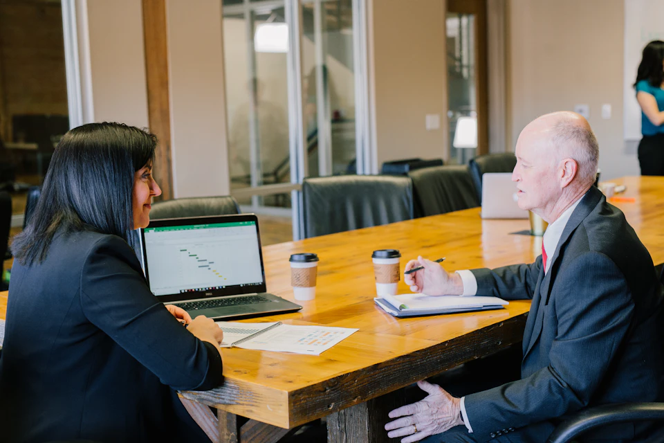Two colleagues reviewing work at a table; illustrative stock photography